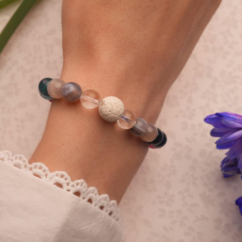 Wrist shot of handmade lava stone and blue chalcedony bracelet with agate and quartz – serene and stylish on skin.