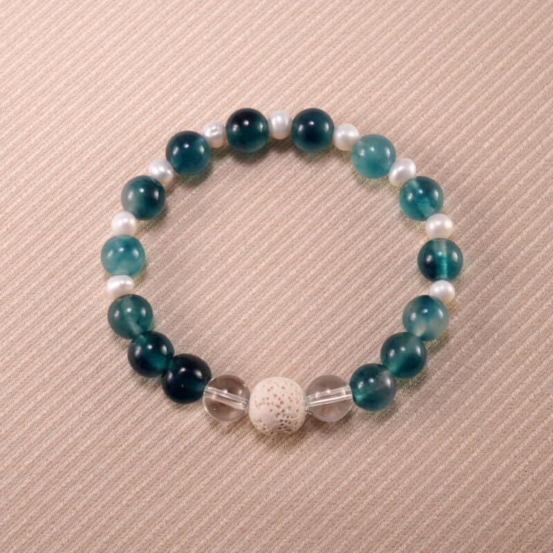 Handmade bracelet with lava stone, blue chalcedony, freshwater pearl, and clear quartz – elegant and soothing crystal piece.