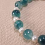 Close-up image highlighting the contrast between matte lava stone and smooth chalcedony, pearl, and quartz.