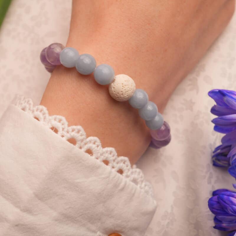 The bracelet worn on the wrist, showcasing the calming tones of amethyst and chalcedony.