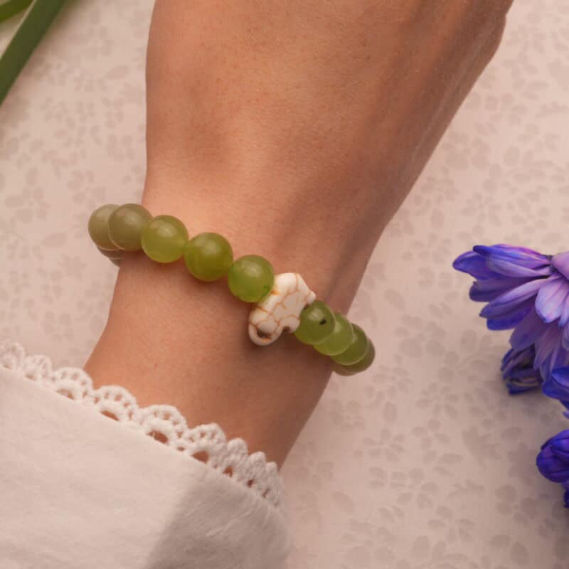 Wrist shot showing the green and white chalcedony bracelet stacked with casual wear.