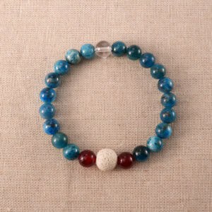 Handmade bracelet with Lava Stone, Red Agate, and Blue Fluorite beads arranged on a neutral background.