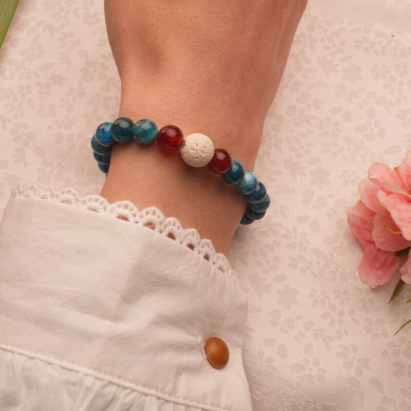Wrist shot of the lava stone and gemstone bracelet worn with a casual outfit.
