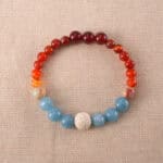Handmade bracelet featuring Lava Stone, Red Agate, Shoushan Stone, and Blue Chalcedony beads displayed flat on a light background.