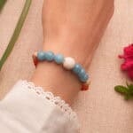 Model wearing the bracelet with natural gemstone beads in a casual outfit setting.