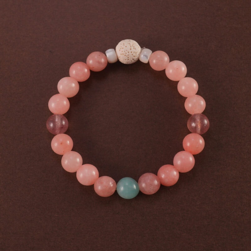 Handmade bracelet featuring lava stone, rose chalcedony, strawberry quartz, and amazonite beads arranged in a soothing pastel palette.