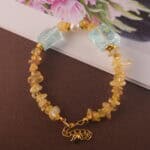 Side angle showing the arrangement of golden rutilated quartz, pearl, and aquamarine, with attention to bead texture and clarity.