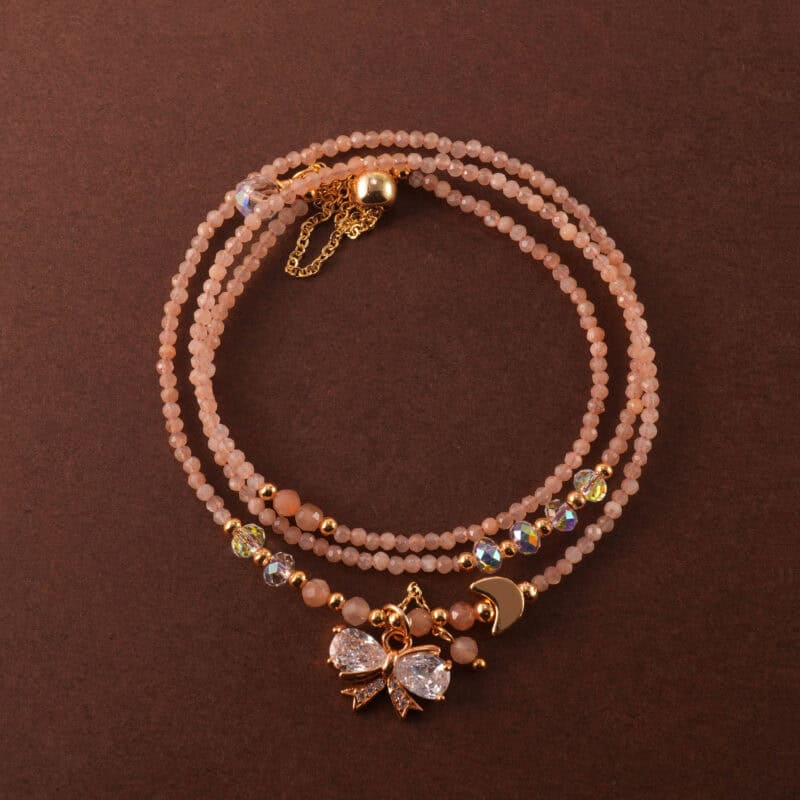 Handmade rose quartz necklace that can also be worn as a three-wrap bracelet, shown coiled elegantly.