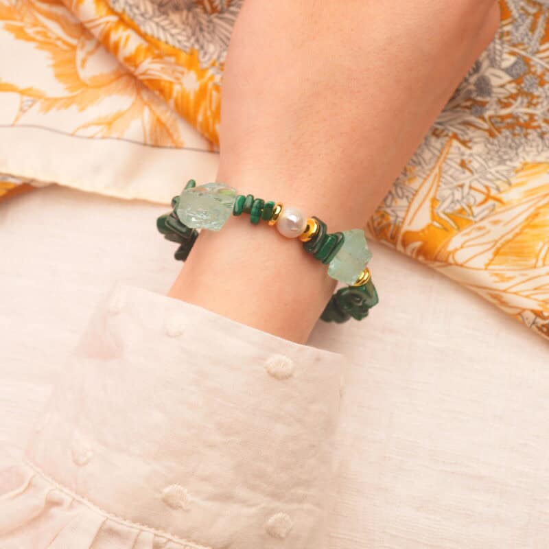 The Scorpio bracelet styled on wrist, showing the vibrant green malachite and ocean-toned aquamarine against the skin.