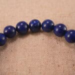 Close-up of lapis lazuli bracelet with S925 silver charm.