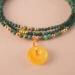 Close-up of malachite beads showing their natural banding patterns and smooth polished surface.