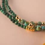 Close-up of malachite beads showing their natural banding patterns and smooth polished surface.