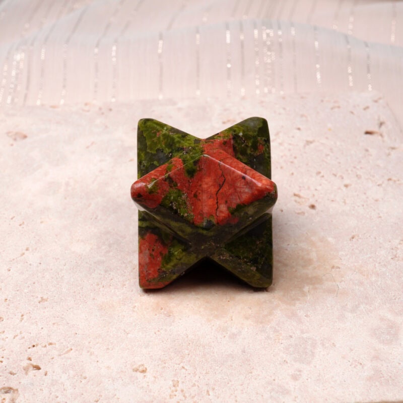Natural Unakite Merkaba ornament placed on a light stone surface