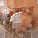 Peach moonstone and white agate bracelet displayed in soft natural light.