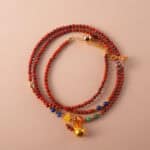 A vibrant multi-use necklace made with red agate and lapis lazuli beads, coiled in a spiral layout to showcase the bold color contrast.