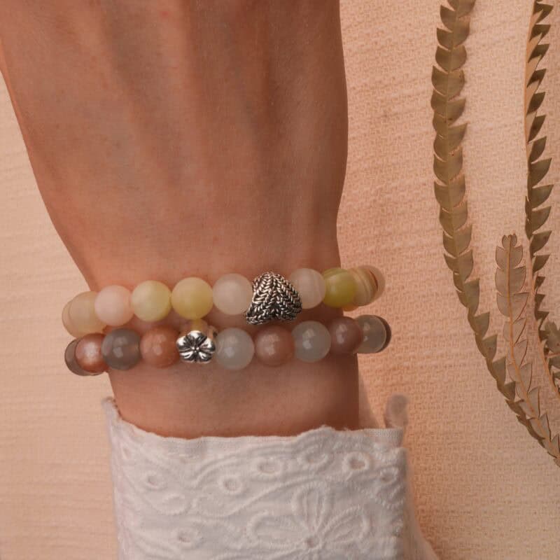 Model wearing Afghan jade and moonstone bracelets stacked together.