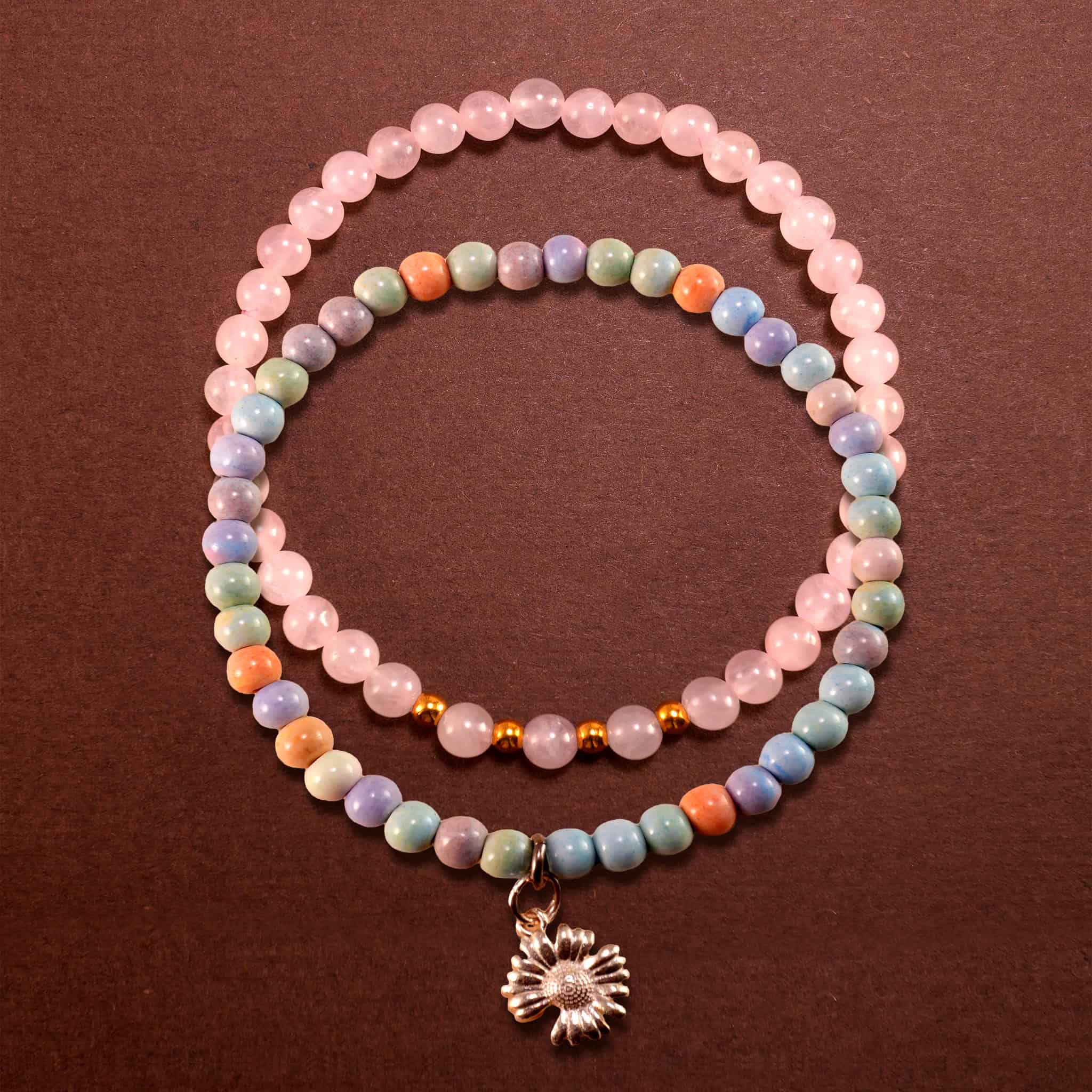 Main image of stacked bracelets with natural and pink stones.