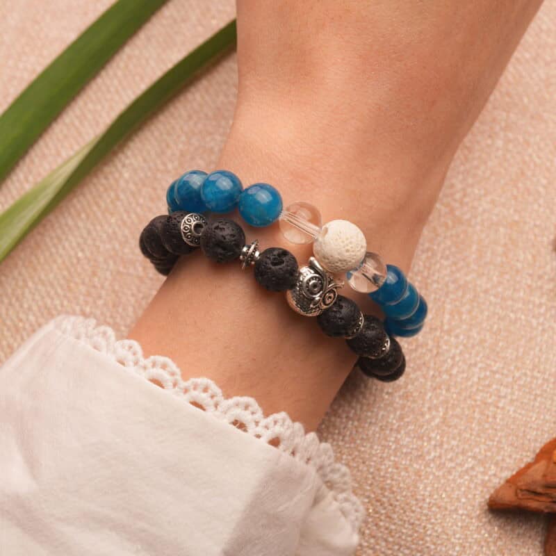 Model wearing stacked lava and gemstone bracelets.