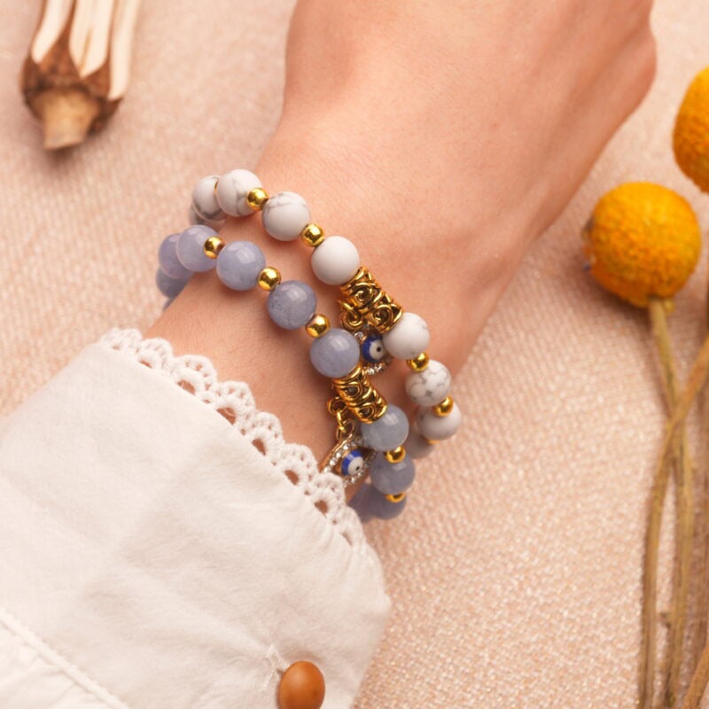 Model wearing stacked evil eye bracelets with protective energy.