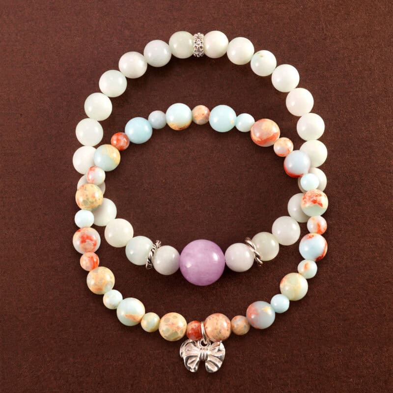 Main image of stacked bracelets with soft white and earthy tones.
