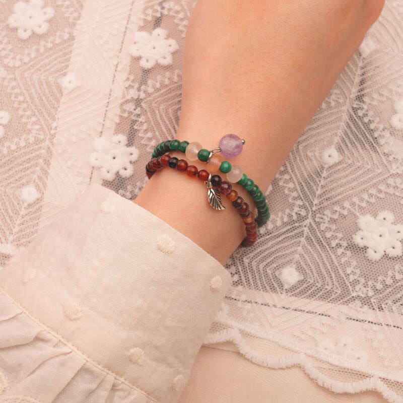 Model wearing gemstone stack in bold contrasting tones.