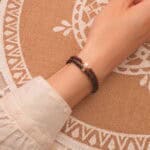 Model wearing elegant gemstone stack in classic tones.