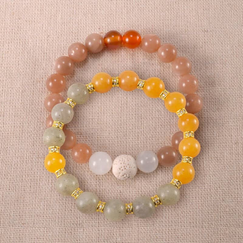 Main image of stacked bracelets in gray, yellow, and peach tones.