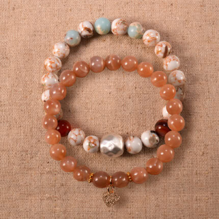 Main image of stacked bracelets in soft peach and beige tones.