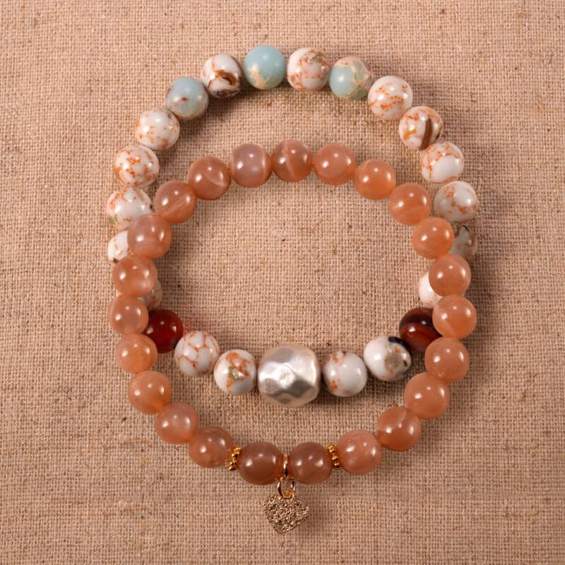 Main image of stacked bracelets in soft peach and beige tones.