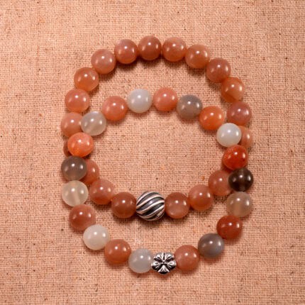 Main image showing stacked bracelets: peach moonstone and white agate mix.