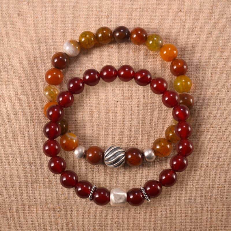 Main image of stacked red agate bracelets in deep and rich tones.
