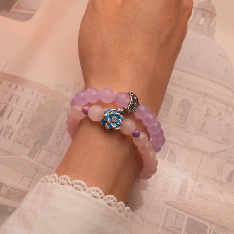 Model wearing stacked rose quartz and amethyst bracelets.