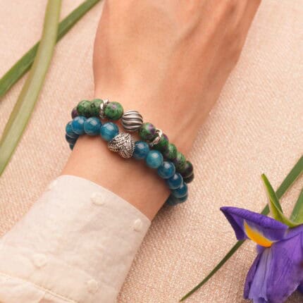 Model wearing stacked ruby in zoisite and blue apatite bracelets.