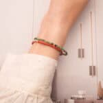 Model wearing stacked ruby zoisite and red agate bracelets on wrist.