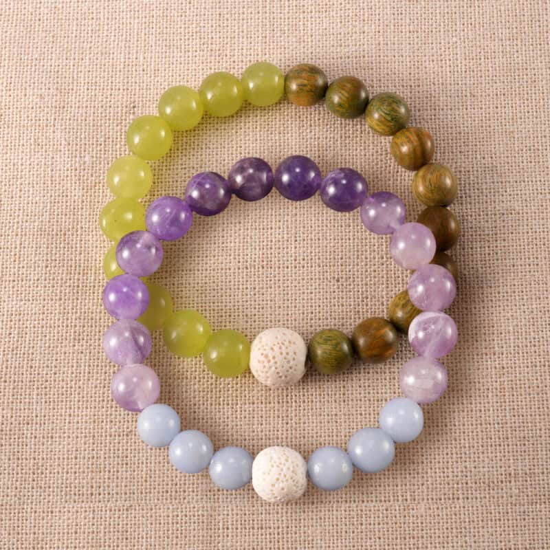Main image of stacked bracelets with wood, crystal, and stone.