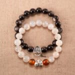Main image of stacked silver obsidian and white-orange gemstone bracelets.