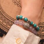 Model wearing bright and soft gemstone bracelets in a layered look.