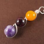 Close-up of Virgo necklace showing yellow agate, garnet, and amethyst beads.