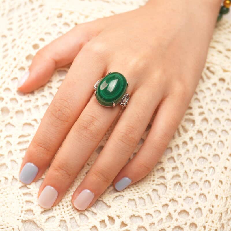 Open malachite ring shown on a hand, highlighting its adjustable fit and bold gemstone charm.