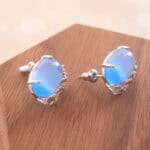 Close-up of the blue cat’s eye studs highlighting their natural glow and smooth texture.