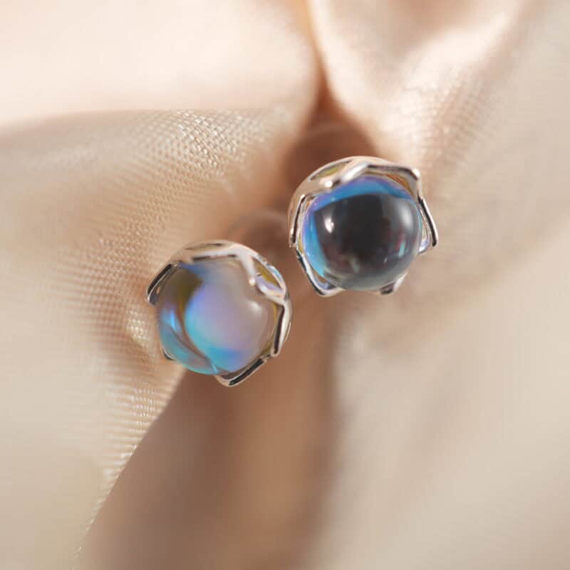 A pair of blue sheen moonstone stud earrings displayed on a clean background, showcasing their dreamy glow.