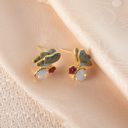 A pair of butterfly-shaped opal stud earrings with soft, iridescent tones and delicate design.