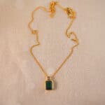 Emerald pendant necklace on white background