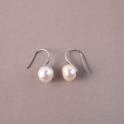A pair of natural pearl stud earrings on a white background, showcasing their simple and elegant luster.