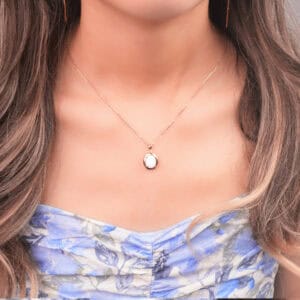 Model wearing opal pendant necklace
