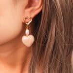 Model wearing the pearl heart earrings, creating a soft and feminine aesthetic.