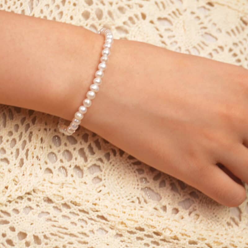 Model wearing the pearl stretch bracelet, showcasing elegant wrist lines and feminine charm.