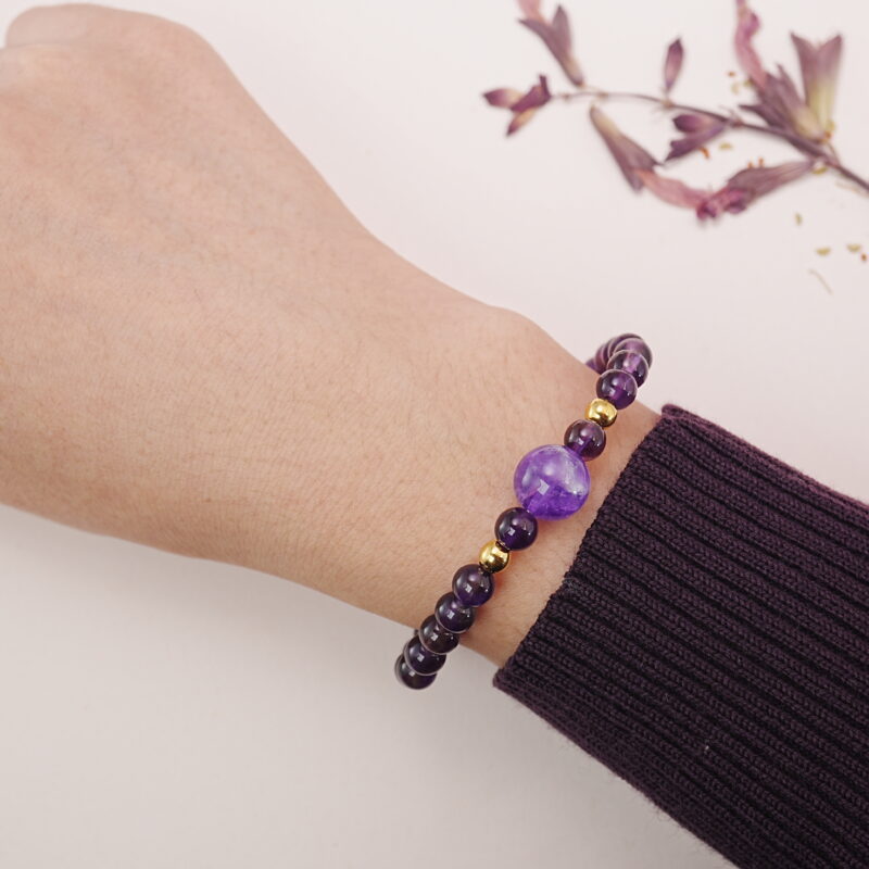 A model wearing the Amethyst and Black Tourmaline bracelet on their wrist. The bold purple and black tones create a striking, yet calming effect, ideal for any occasion.