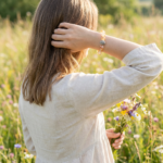 A woman seen from behind wearing a crystal bracelet outdoors, capturing a peaceful and natural lifestyle moment.