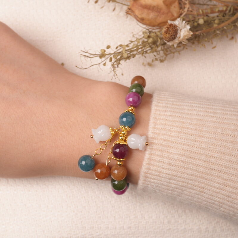 Model wearing multicolor tourmaline bracelet with gourd charm, showing elegant and vibrant style.